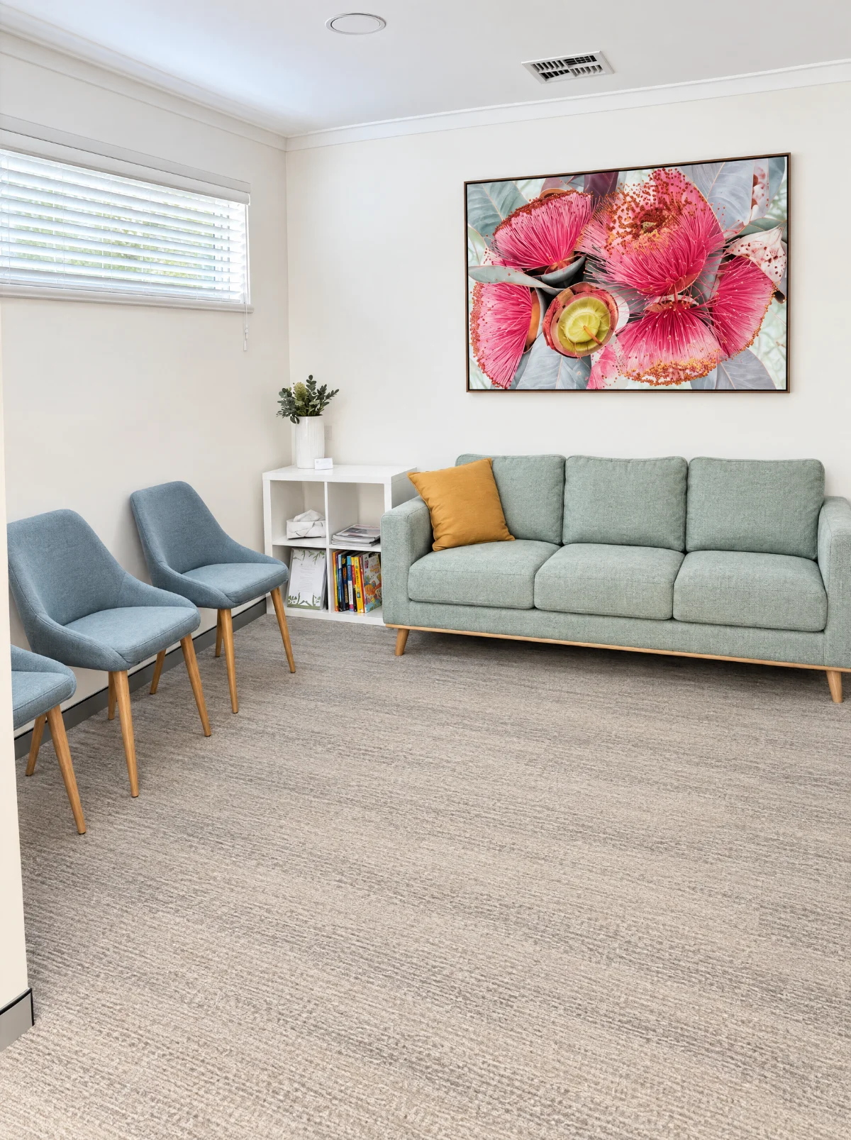 The Booragoon lounge: a sage sofa, grey-blue chairs with timber legs and a large gum blossom painting