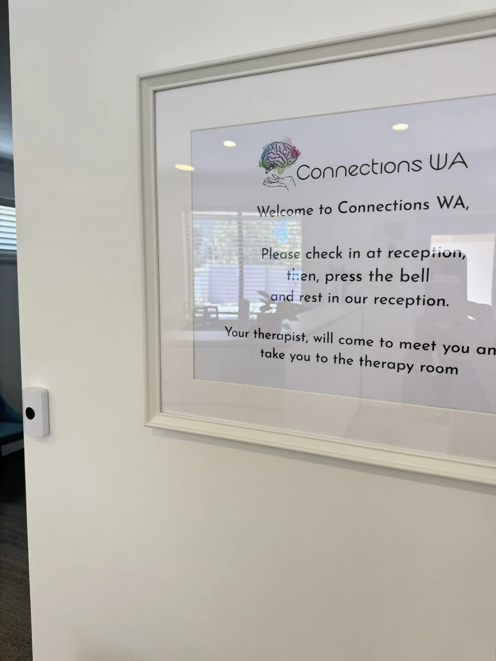 A welcome sign asking visitors to check in at reception and press the bell