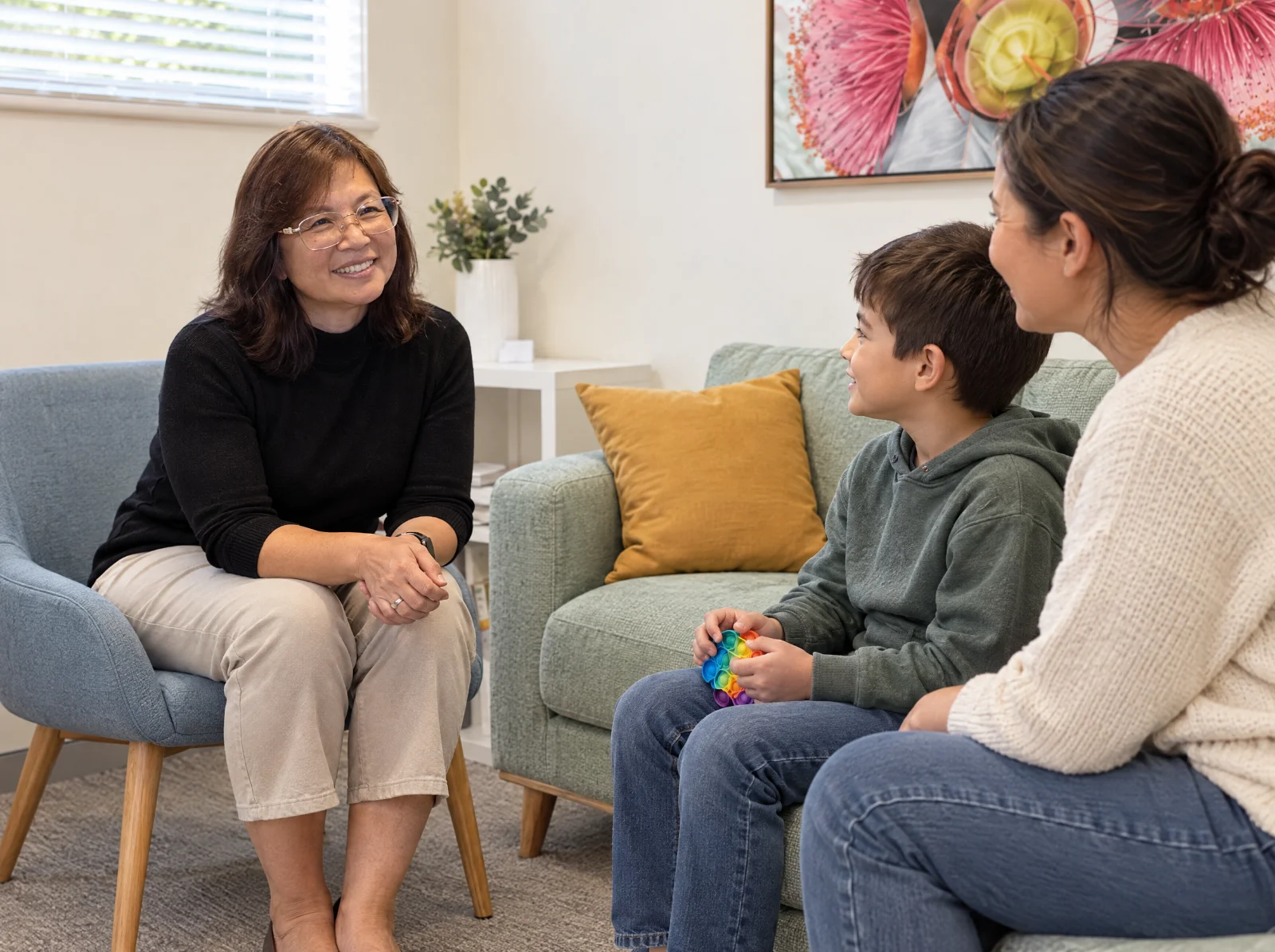 Wendy, one of our psychologists, talks with a parent and child on the sofa.