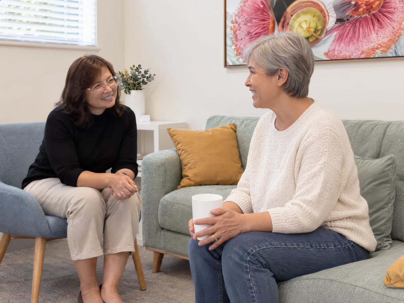 Illustrative image: a psychologist talking with an adult woman in a calm therapy room.